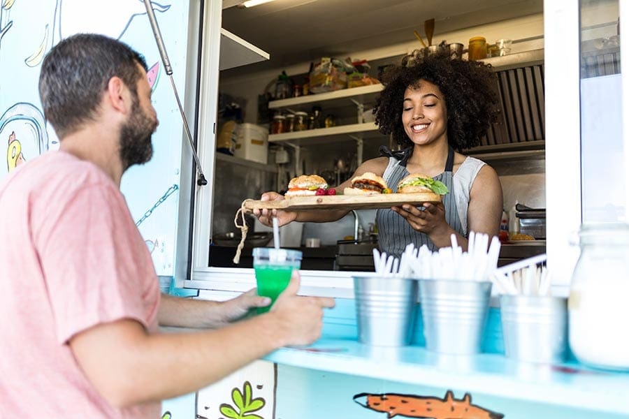 Customer taking burgers from food van